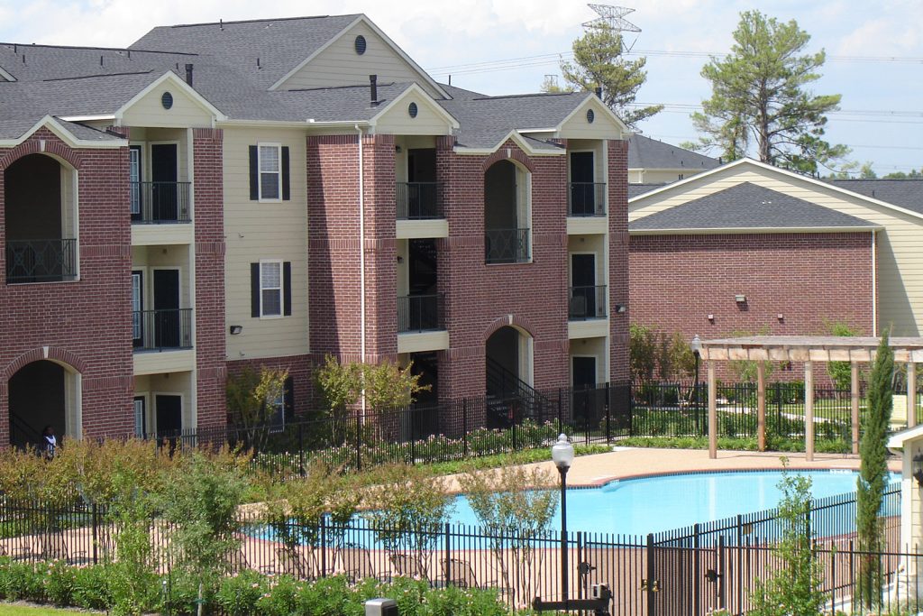 Image of one of the Northland Woods apartment buildings next to the gated property pool.